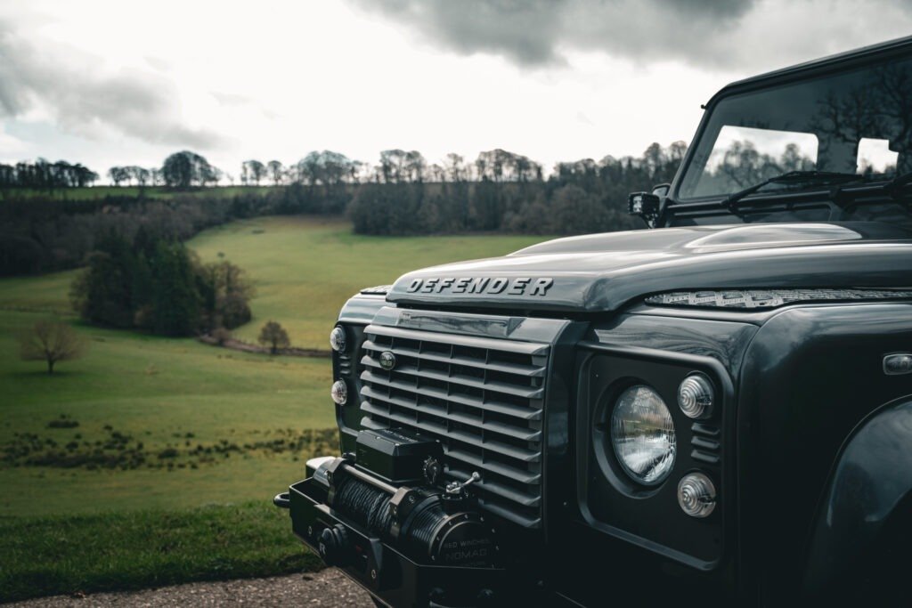 Defenders in Somerset Black Land Rover Defender driving through muddy Somerset woodland track